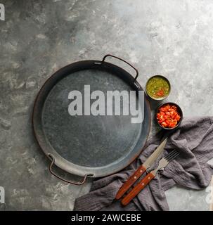 Kolumbianische Küche, aji picante, hogao salsa, auf der Metallschale und Zutaten für Souce, auf der grauen Betonkulisse, Platz für Designtext Stockfoto