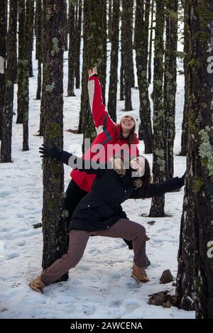 Junge fröhliche und schöne Mädchen im Teenager-Alter, die sich im Winter in Winterkleidung kleiden und im Schnee plaudern. Troodos Berge auf Zypern Stockfoto