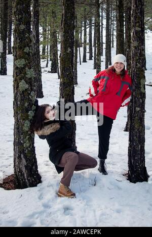 Junge fröhliche und schöne Mädchen im Teenager-Alter, die sich im Winter in Winterkleidung kleiden und im Schnee spielen. Troodos Berge auf Zypern Stockfoto