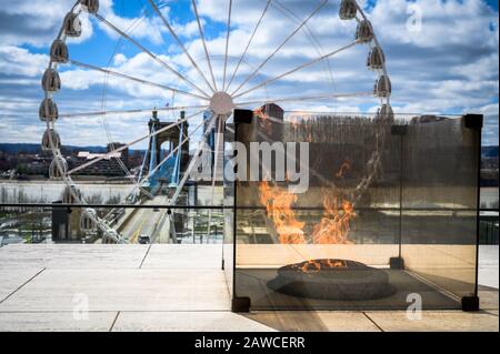 Freedom's Flame im National Underground Railroad Center in Cincinnati, Ohio mit Blick auf das SkyStar Wheel und die Roebling Bridge Stockfoto