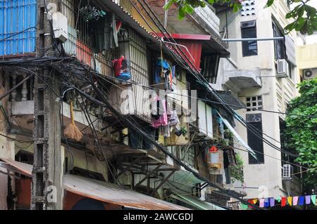 Unordentliche verschlungene Elektrizität, Telekommunikationsleitungen, Kabel an Polen in Hanoi, Vietnam Stockfoto