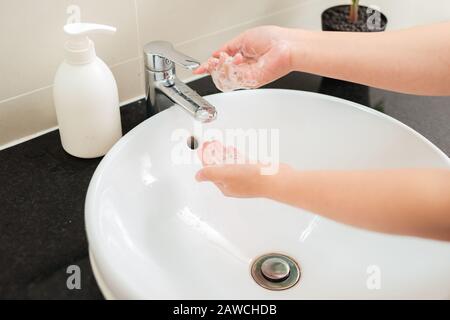 Frau wäscht die Hände unter fließendem Wasser Stockfoto