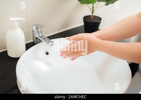 Frau wäscht die Hände unter fließendem Wasser Stockfoto
