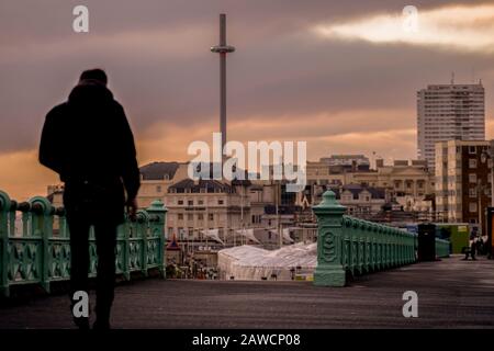 Mann, der am Strand von Brighton spazieren geht Stockfoto