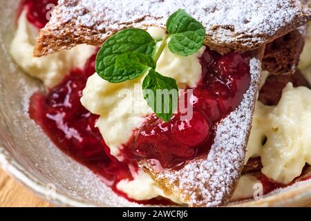 Millefeuille Dessert mit Beerenstau auf einem Holztisch Nahaufnahme Stockfoto