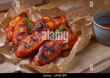 Würzige heiße Hühnerflügel, mit Honig und Soja gekocht, Nahaufnahme auf rustikalem Holzhintergrund. Stockfoto