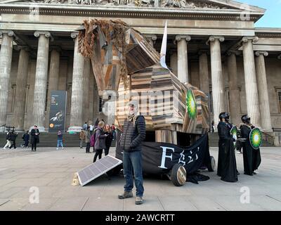 BP oder Nicht BP-Aktivist Phil Ball, steht mit einem Trojaner-Pferd, das er vor dem British Museum, London, aus Protest gegen BP entworfen hat, die die Troy-Ausstellung im Museum sponsert. Stockfoto