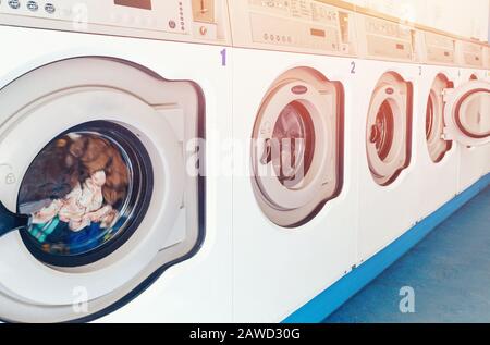 Reihe von industriellen Waschmaschinen im kommerziellen Waschsalon. Concept Business Wascherei. Stockfoto