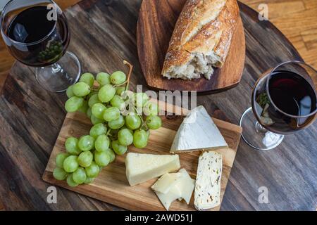 Rotwein- und Käseplatte mit Brot und Trauben, oberster Schuss Stockfoto