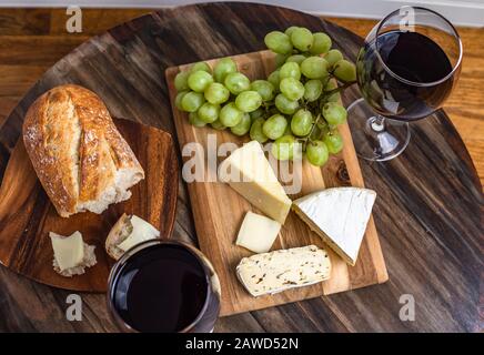 Rotwein- und Käseplatte mit Brot und Trauben, oberster Schuss Stockfoto