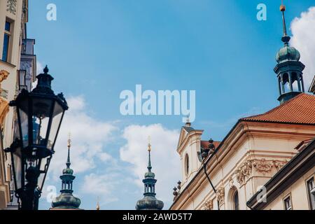 Kuppeln der Glockentürmkirche in der Altstadt gegen klaren blauen Himmel, elektrische schmiedeeisernen Laternen verschwommen im Vordergrund Stockfoto