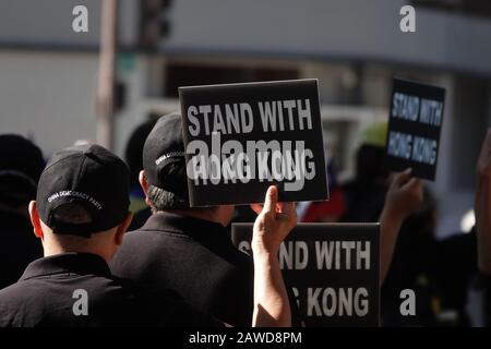 24. November 2019: LESESTAND mit HONGKONG wird von nicht identifizierten Männern mit Hüten gehalten, die mit DER PARTEI DER CHINESISCHEN DEMOKRATIE bestickt sind. Stockfoto