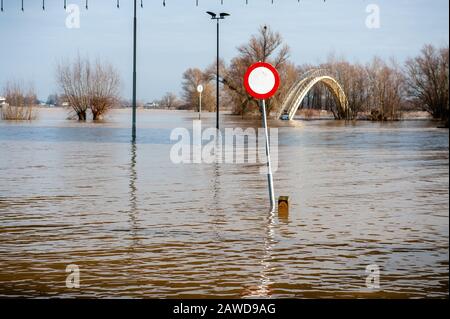 Nijmegen, Gelderland, Niederlande. Februar 2020. Ein fast unter Wasser lieendes Verkehrszeichen an der Hochwasserzone.Überschwemmungsgebiete am Rheinufer und andere größere Flüsse sollen sich am späteren Wochenende stellenweise unter Wasser befinden. Nijmegen ist eine der niederländischen Städte, die jetzt von diesem hohen Wasserstand betroffen sind. Die Waalkade, die Zone näher am Fluss, wurde für den Verkehr gesperrt und es wird erwartet, dass das Wasser eine Höhe von mehr als 11 Metern über dem Meeresspiegel erreichen kann. Das Rheinwasser bei Lobith, wo der Fluss in die Niederlande übergeht, soll rund 14 Meter erreichen Stockfoto