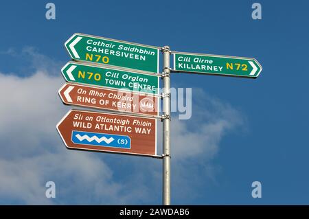 Ring of Kerry und Wild Atlantic Way zweisprachige Richtung Straßenschilder in Englisch und Gälisch Irisch in der Nähe von Killorglin, County Kerry, Irland Stockfoto