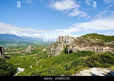 Felsformationen der Meteora-Berge und des Klosters in Griechenland mit blauem Himmel und grünem Wald Stockfoto