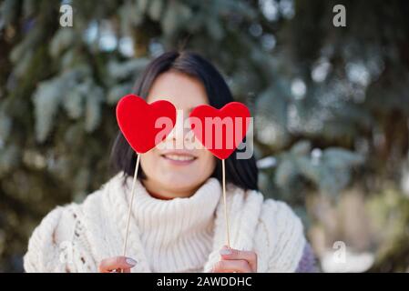 Liebe ist überall. Mädchen schließt Augen mit Papierherzen, liebenswürdig Mädchen mit valentinssymbol. Feiert Saint Valentine Day Love Beautiful Concept. Stockfoto