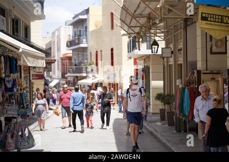 Athen, Griechenland - 18. Mai 2019: Touristen gehen durch die Straßen, die von Souvenirläden und Straßencafés im Freien im touristischen Plaka-Gebiet von Athen, Gr., gesäumt sind Stockfoto