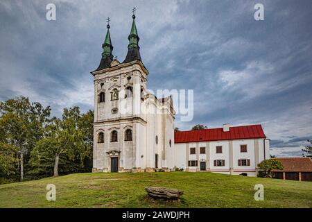 Krahulci/Tschechien - 27. September 2019: Blick auf eine auf grünem Hügel stehende, weiße Johannes von Nepomuk Kirche aus dem 18. Jahrhundert. Stockfoto