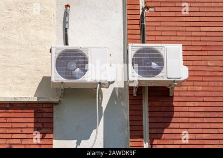 An der Hauswand hängen Klimaanlagen. Stockfoto