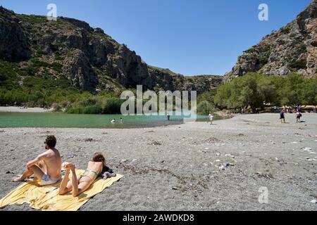 Crete, Griechenland, Preveli Beach, 24. Mai 2019: Touristen genießen Preveli Strand am libyschen Meer, Fluss und Palmenwald, Südkrete, Griechenland im Sommer Stockfoto