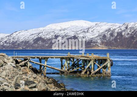 Anlegesteg in Kvalsund, schneebedeckte Berge, Insel Kvaloya, Troms, Norwegen Stockfoto