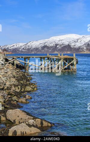 Anlegesteg in Kvalsund, schneebedeckte Berge, Insel Kvaloya, Troms, Norwegen Stockfoto