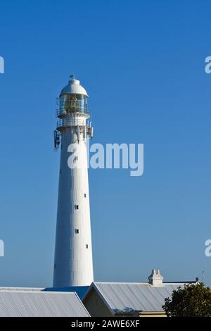 Tall White Lighthouse Tower Über Dächern Stockfoto