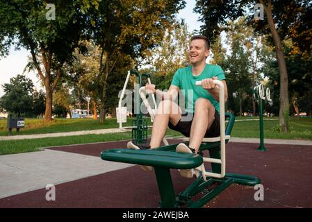 Schöner mann Training im Fitnessbereich im Freien am Rudergerät Stockfoto