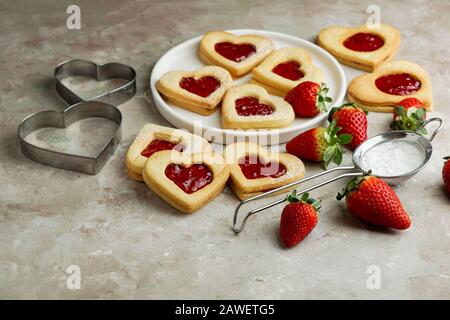 Plätzchen in Form von Herzen mit Erdbeermarmelade, St. Valentinstag konsept Stockfoto