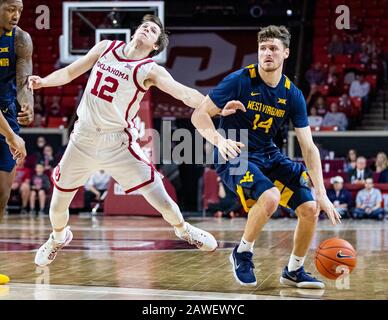 Norman, Oklahoma, USA. Februar 2020. West Virginia Mountaineers Guard Chase Harler (14) fouls Oklahoma Sooners Guard Austin Reaves (12), während er während ihres Spiels am Samstag, 8. Februar 2020 im Lloyd Noble Center in Norman, OK, den Basketball treibt. Credit: Nicholas Rutledge/ZUMA Wire/Alamy Live News Stockfoto