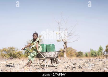 Junge Afrikanische Kleinkinder, Die Tap Water in einem Dorf Transportieren Stockfoto