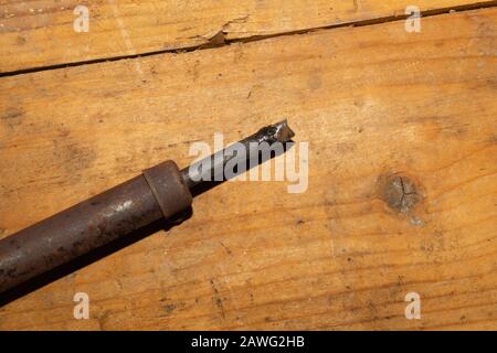 Alter rostiger Lötkolben auf Holztisch. Arbeitswerkzeug Stockfoto