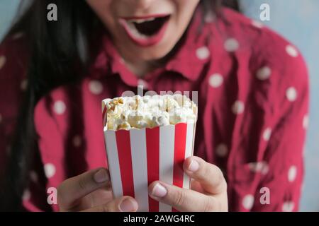 Junge Frauen mit rotem Kleid, die Popcorn essen, Nahaufnahme Stockfoto
