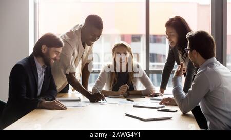 Zufriedene Mitarbeiter, die mit Teamarbeit bei Meetings und Projektbesprachen beschäftigt sind Stockfoto