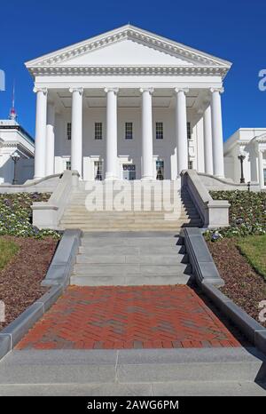 Frontfassade und Gehweg zum neoklassizistischen Virginia State Capitol-Gebäude in Richmond gegen einen leuchtend blauen Himmel Stockfoto