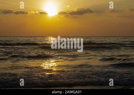 Schöner Blick auf die Wellen und die Fischerboote entlang des Marina Strandes während des Sonnenaufgangs, Chennai, Indien. Fischer wagten sich während der e Stockfoto