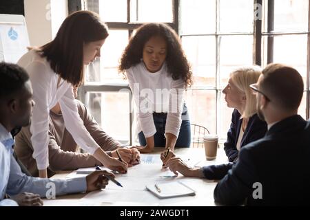 Die Gruppe der multiethnischen Geldgeber führt statistische Datenanalysen zu Finanzergebnissen durch Stockfoto