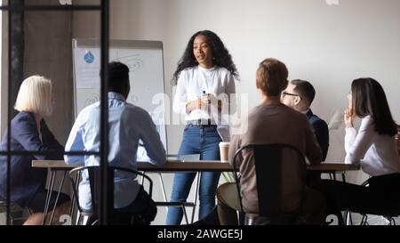 Die Moderatorin der afrikanischen Ethnie macht Präsentationen für Geschäftsleute aus mehreren ethnischen Gruppen Stockfoto