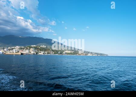 Blick vom Meer auf die Stadt Jutta an der Südküste der Krim an einem sonnigen Tag. Stockfoto