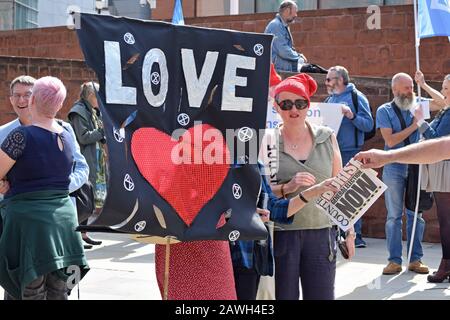 Starten Sie die Demokratie-Kundgebung am 200. Jahrestag des Peterloo-Massakers am Petersplatz Manchester neu. Frau, die mit Liebe und Herz Banner hält. Stockfoto