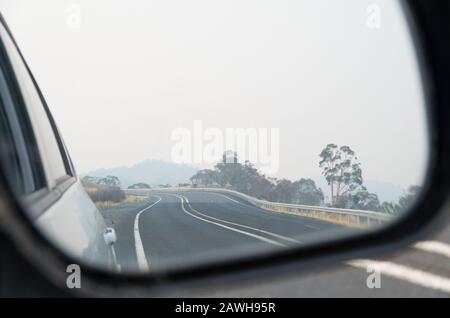 Schneebedeckte Berge in australien, die von einem Rauchschas bedeckt sind, der durch nahe gelegene Buschfeuer durch einen Flügelspiegel verursacht wird Stockfoto