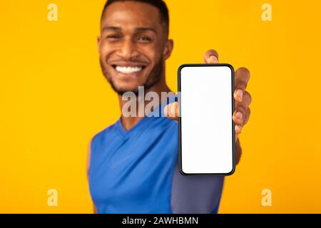 Schwarzer, tausendjähriger Mann mit weißem leerem Telefon Stockfoto