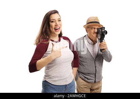 Junge Casual Woman lacht über einen älteren Mann mit einer Vintage-Aufnahmekamera isoliert auf weißem Hintergrund Stockfoto