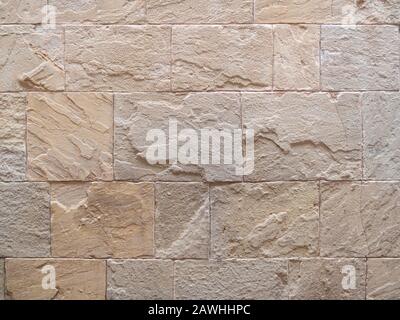 Hintergrundtextur aus antiker Steinwand. Steinmetzmauerwerk. Rosafarbene Sandfarbe. Stockfoto
