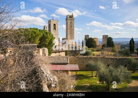 Aussicht auf die Dächer und Türme mit Bäumen und blauen sonnigen Himmel von San Gimignano. Eine tolle mittelalterliche Stadt berühmt für mehrere Türme in seiner Historica Stockfoto