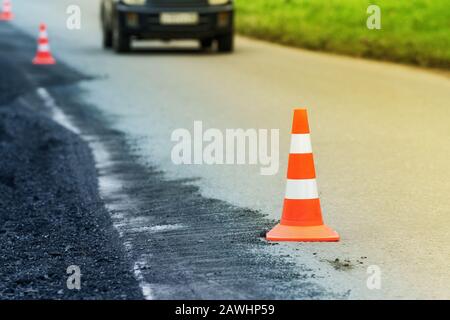 Warnung Verkehrsampel während der Straßenreparatur auf Asphalt Straße gesetzt, Asphaltpflaster arbeiten auf der Automobil-Autobahn. Nicht erkennbares Auto Stockfoto