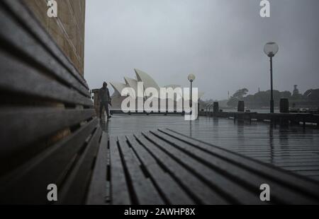 Sydney, Australien. Februar 2020. Am 9. Februar 2020 spaziert ein Bürger in Sydney, Australien, im Regen. Am Freitag trifft eine gewaltige Niederschlagsmenge auf die vom Buschfeuer verwüstete Ostküste Australiens. Inmitten der schlimmsten Trockenheit, die zu verzeichnen ist, wird der gewaltige Niederschlag am Freitag voraussichtlich mindestens eine Woche andauere und den lang leidenden Gemeinden Erleichterung bringen. Obwohl der Regen meist als gute Nachricht angesehen wird, warnen die Behörden auch, dass brandgeschädigte Bereiche extrem hochwassergefährdet sind. Kredit: Bai Xuefei/Xinhua/Alamy Live News Stockfoto