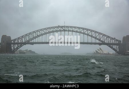 Sydney. Februar 2020. Das am 9. Februar 2020 aufgenommene Foto zeigt die Harbour Bridge in Rain in in Sydney, Australien. Am Freitag trifft eine gewaltige Niederschlagsmenge auf die vom Buschfeuer verwüstete Ostküste Australiens. Inmitten der schlimmsten Trockenheit, die zu verzeichnen ist, wird der gewaltige Niederschlag am Freitag voraussichtlich mindestens eine Woche andauere und den lang leidenden Gemeinden Erleichterung bringen. Obwohl der Regen meist als gute Nachricht angesehen wird, warnen die Behörden auch, dass brandgeschädigte Bereiche extrem hochwassergefährdet sind. Kredit: Bai Xuefei/Xinhua/Alamy Live News Stockfoto