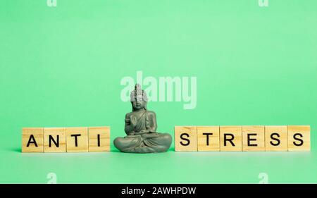 Anti-Stress-Konzept. Die Aufschrift Stressfrei auf einem rein grünen Hintergrund mit einer meditierenden Figur. Stressreduzierung und -Kontrolle. Stockfoto