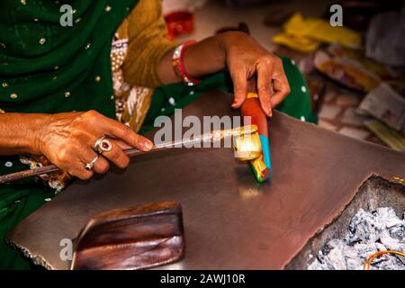 Indien, Rajasthan, Shekhawati, Nawalgarh, die traditionellen lac Bangles von Hand formt, Muster bildet, die geschmolzene Goldfarbe an der Winkelbasis anheftet Stockfoto